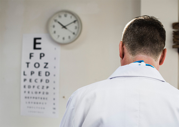 doctor standing by eye chart